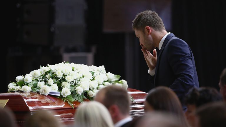Australia cricket captain Michael Clarke pays his respects during the funeral service in Macksville