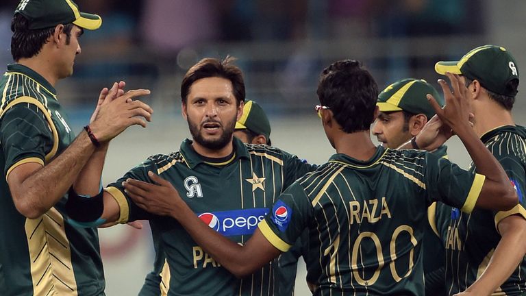 Pakistan's Twenty20 cricket captain Shahid Afridi (2L) celebrates with teammate after taking the wicket of New 