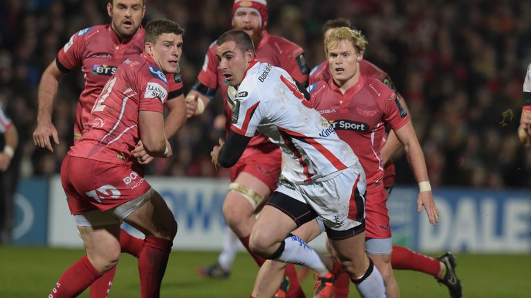 BELFAST, NORTHERN IRELAND - DECEMBER 6:  Ruan Pienaar of Ulster (C) evades the tackle of Scott Williams (L) of Scarlets to score a try during the European 
