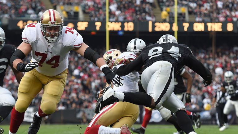 OAKLAND, CA - DECEMBER 07:  Colin Kaepernick #7 of the San Francisco 49ers is tackled by Antonio Smith #94 of the Oakland Raiders while Joe Staley #74 of t