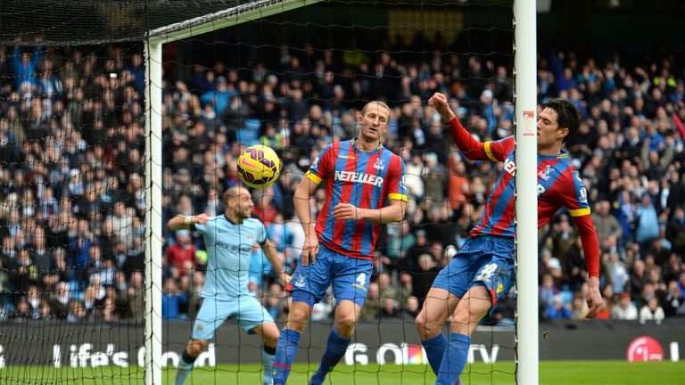 Crystal Palace defenders Brede Hangeland (C) and Martin Kelly (R) are unable to stop the ball crossing the line as Man City's David Silvaopens the scoring