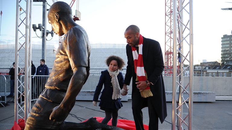 Henry takes a look at his statue outside the Emirates with his daughter Tea.