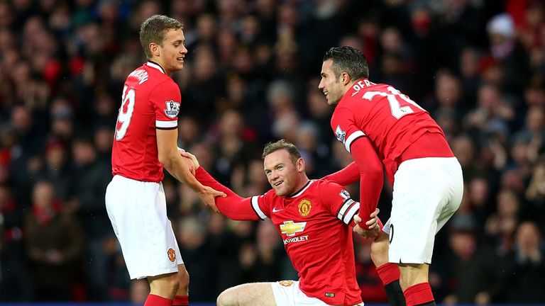 Wayne Rooney of Manchester United is helped to his feet by James Wilson and Robin van Persie after scoring