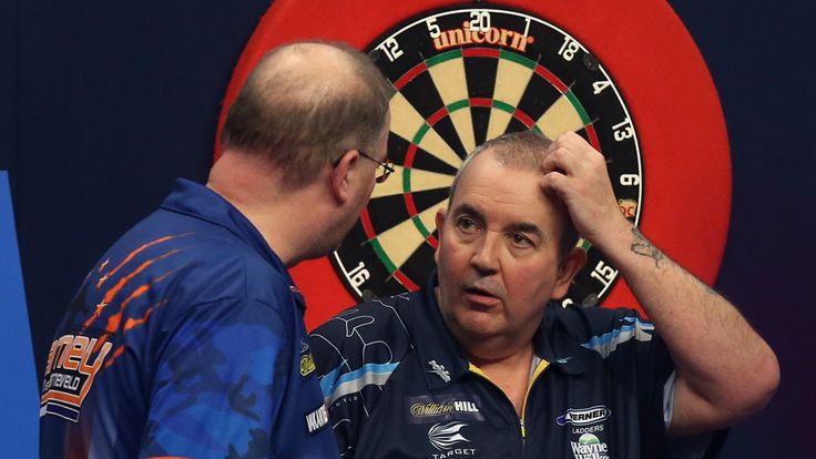 Phil Taylor (right) chats with Raymond van Barneveld, (left) after defeating him during the William Hill World Darts Championship at Alexandra Palace