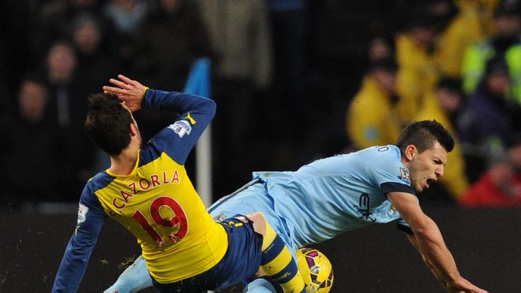 Manchester City's Sergio Aguero (R) is fouled by Arsenal's Santi Cazorla