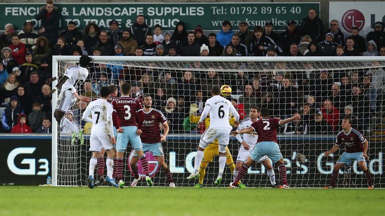 Swansea's Bafetibi Gomis climbs to head the ball goalwards, leading to an own goal by Mark Noble