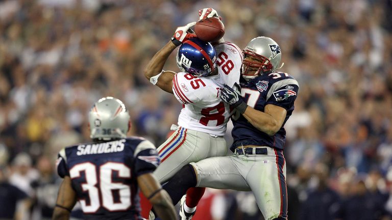 David Tyree #85 of the New York Giants catches a 32-yard pass against Rodney Harrison #37