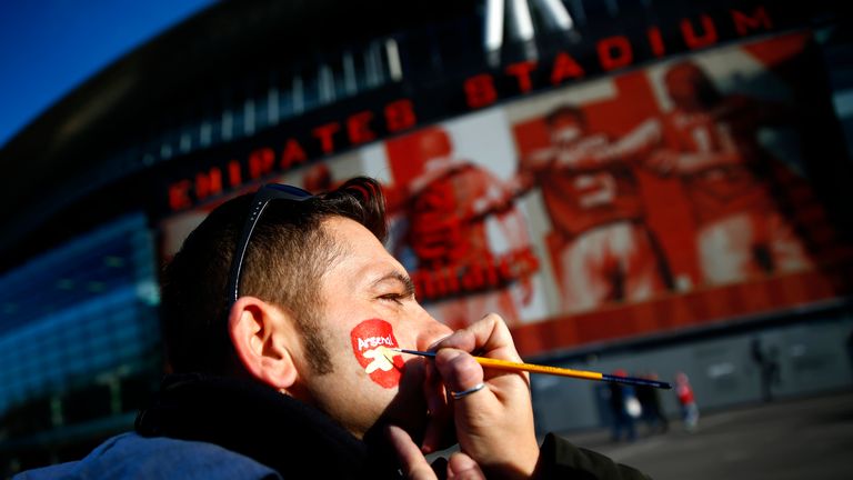A fan has his face painted outside the Emirates stadium.