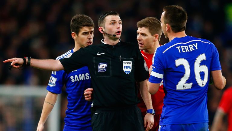 Michael Oliver is surrounded by Liverpool and Chelsea players.