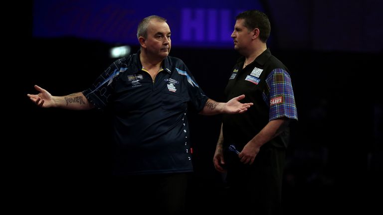 Phil Taylor celebrates hitting a maximum as Gary Anderson looks on during the final of the 2015 Willliam Hill World Darts Championship