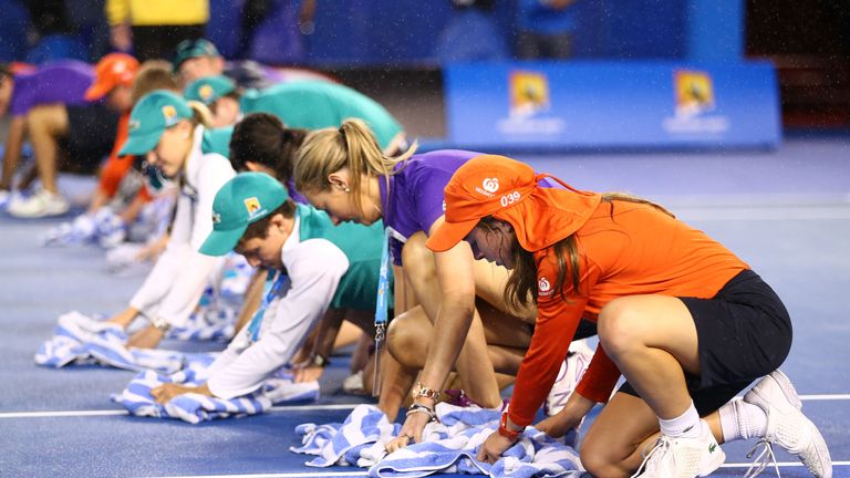 Ball kids wipe the court after rain fell during day 13 of the 2015 Australian Open at Melbourne Park on January 31, 201