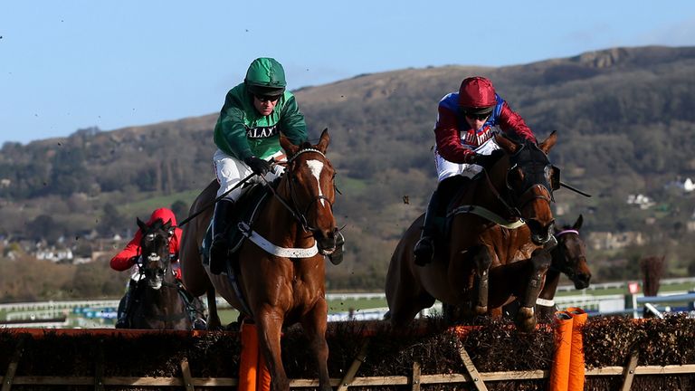 Peace and Co ridden by Barry Geraghty (left) jumps the last with Zarib ridden by Harry Skelton (right) on their way to victory in the JCB Triumph Hurdle Tr