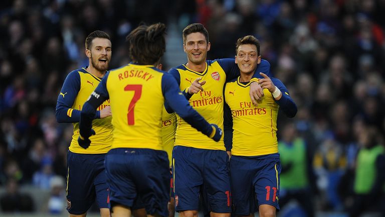 Mesut Ozil celebrates with his teammates after scoring Arsenal's second goal.