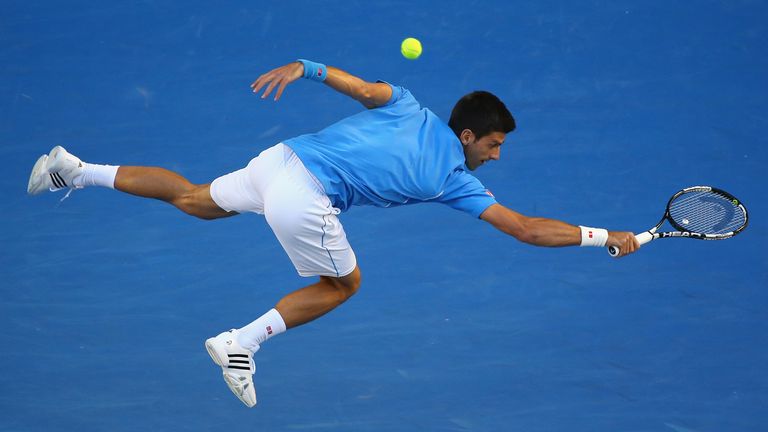 Novak Djokovic of Serbia plays a backhand in his quarter final match against Milos Raonic of Canada 