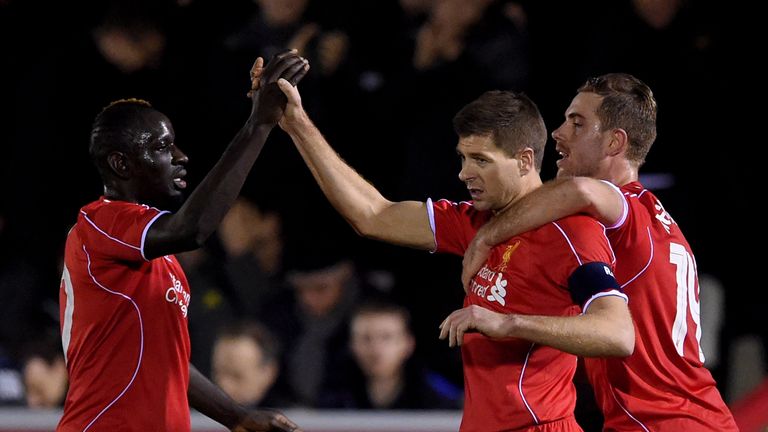 KINGSTON UPON THAMES, ENGLAND - JANUARY 05:  Steven Gerrard of Liverpool is congratulated by teammates Mamadou Sakho (L) and Jordan Henderson (R)