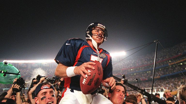 Denver Broncos quarterback John Elway (C) is carried by teammates Ed McCaffrey (L) and Bubby Brister (R) 