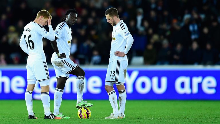 Swansea players Jay Fulton (l), Bafetimbi Gomis (c) and Gylfi Sigurdsson react as they prepare to kick off after going 5-0 down to Chelsea