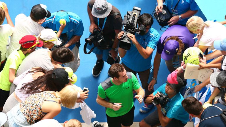 Andy Murray signs autographs after winning in his match against Marinko Matosevic
