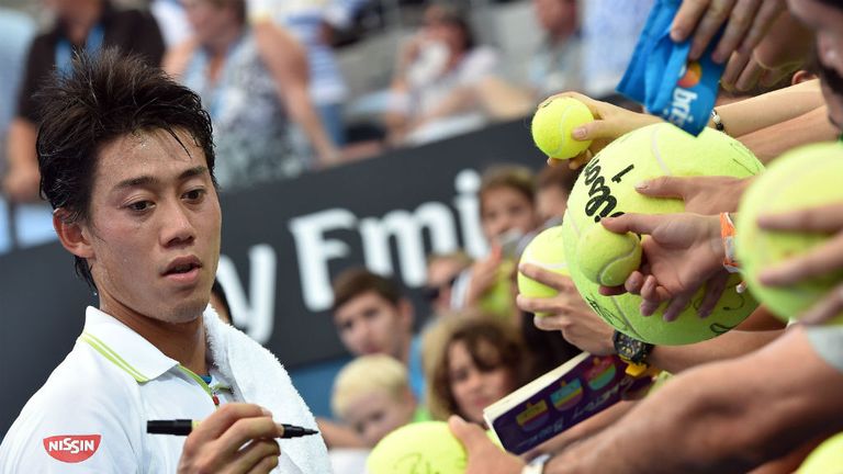 Kei Nishikori signs autographs following his victory over Bernard Tomic in their men's singles quarter-final in Brisbane