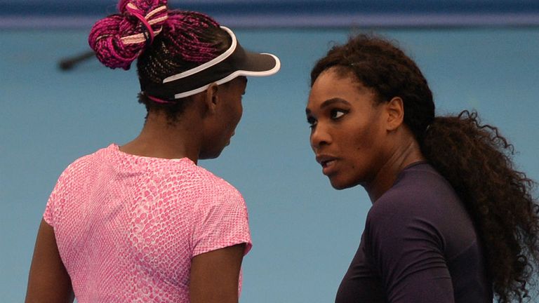Serena Williams (R) talks with her sister Venus (L) during their women's doubles match at the China Open 