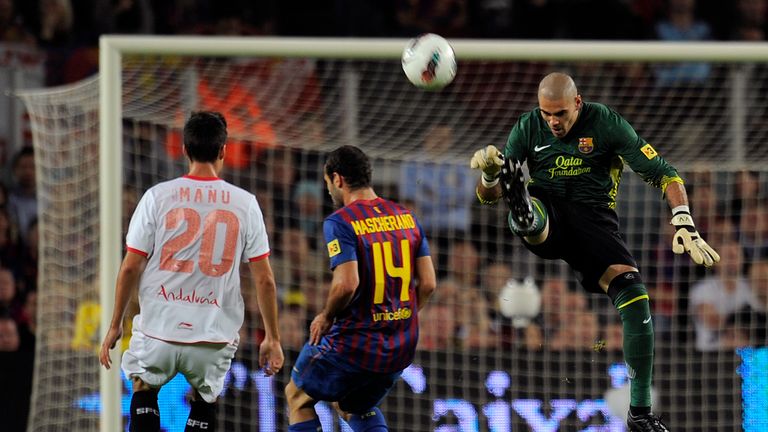 Barcelona's Victor Valdes (R) vies with Sevilla's forward Manu del Moral (L) on his way to a club-record run without conceding.