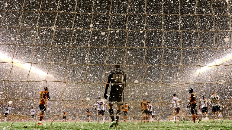  Players in action as snow falls during the FA Cup third round replay match between Wolverhampton Wanderers and Fulham