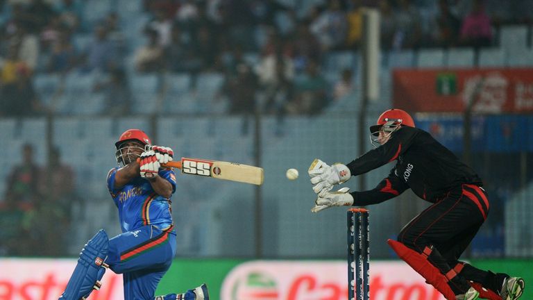Afghan cricketer Mohammad Shahzad (L) plays a shot as Hong Kong captain Jamie Atkinson (R) tries to catch the ball during the ICC Twenty20 World Cup fifth 