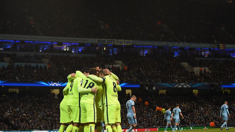 Barcelona players huddle to celebrate their second goal scored by  Luis Suarez (L #9) as Manchester City players (R) return to their positions