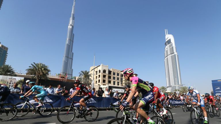 Cyclists pass by the luxury Burj al-Arab Hotel at Jumeirah area during the fourth stage of Dubai tour.