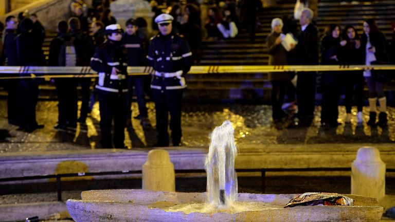 Local police stand guard near the Barcaccia (Sunken Boat) fountain after it was damaged by Feyenoord fans ahead of an Europa League football match