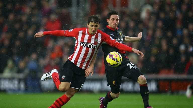 Filip Djuricic of Southampton holds off the challenge from Joe Allen of Liverpool