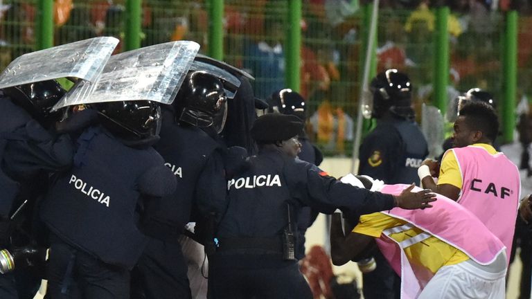 Ghana players leave the pitch protected by riot police