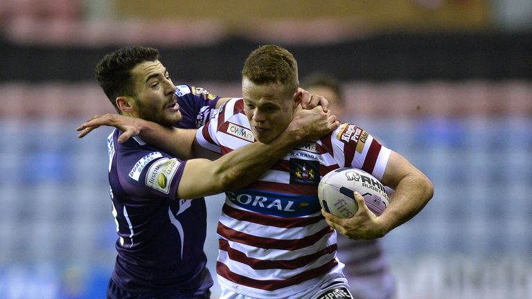 Wigan Warriors' Joe Burgess (right) is tacked by Huddersfield Giants' Jake Connor, during the First Utility Super League match at the DW Stadium, Wigan
