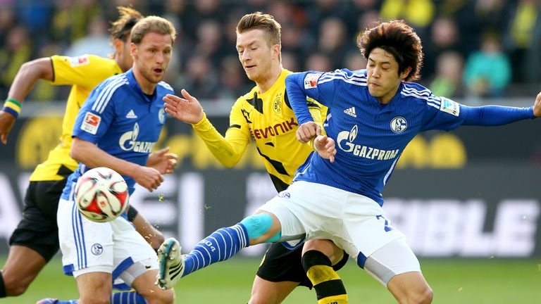 DORTMUND, GERMANY - FEBRUARY 28: Marco Reus (L) of Dortmund battles for the ball with Atsuto Uchida of 