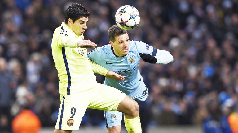 Manchester City's Martin Demichelis (r) challenges Luis Suarez of Barcelona
