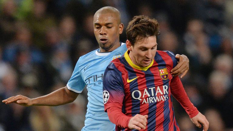 Lionel Messi (R) vies for the ball with Fernandinho 