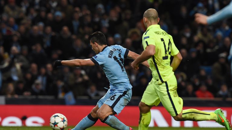 Sergio Aguero (L) shoots to score his team's first goal during the UEFA Champions League match between Manchester City and Barcelona