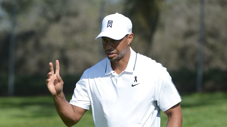 Tiger Woods acknowledges the gallery on the 14th green of the north course during the first round of the Farmers Insurance Open