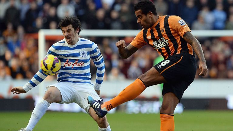 Tom Huddlestone of Hull clears the ball ahead of Joey Barton 