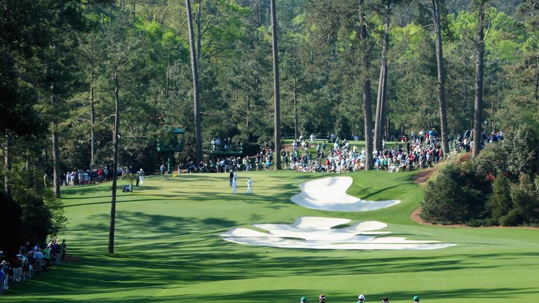 Players and caddies approach the tenth green during a practice round prior to the start of the 2014 Masters Tournament at Augusta 