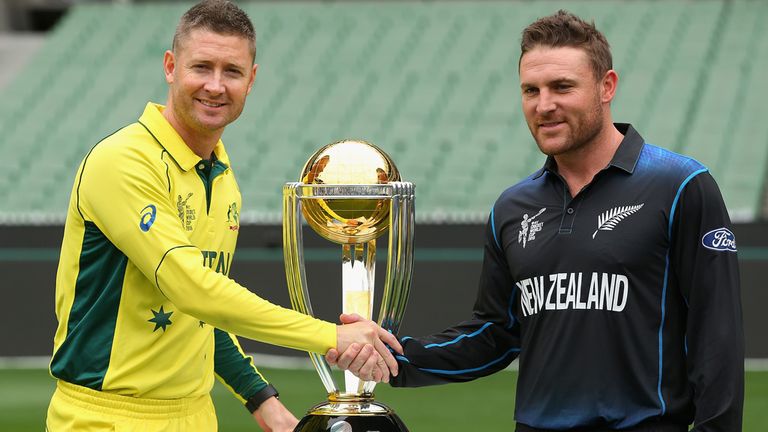 Captains Michael Clarke (L) of Australia and Brendon McCullum of New Zealand pose with the World Cup trophy 