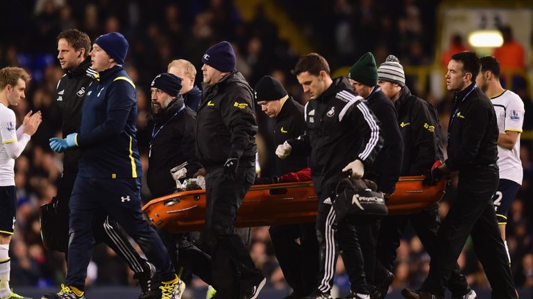 Bafetimbi Gomis of Swansea City is stretchered off during the Tottenham Hotspur and Swansea City