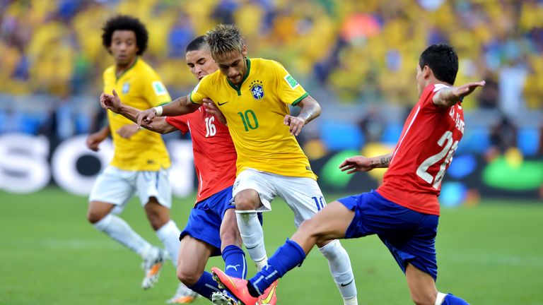 Neymar of Brazil is challenged by Felipe Gutierrez (L) and Charles Aranguiz of Chile during the 2014 FIFA World Cup Brazi