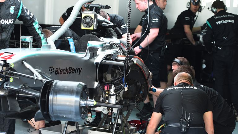 Mercedes mechanics work on Lewis Hamilton's car