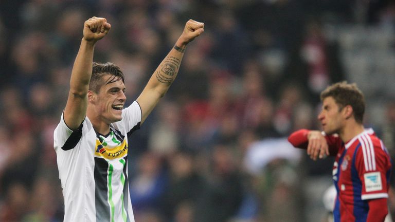 Granit Xhaka of Borussia Moenchengladbach celebrates victory in front of a dejected Thomas Muller