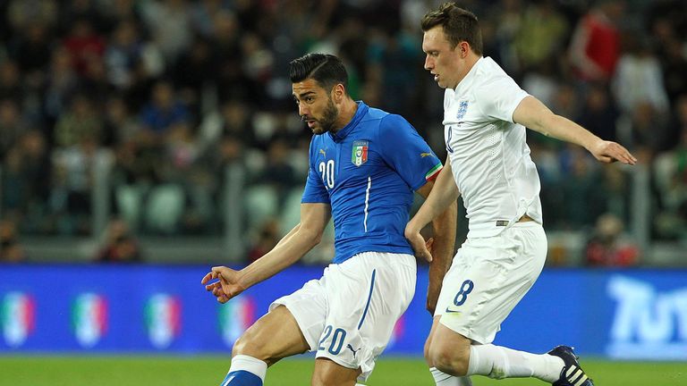 Graziano Pelle of Italy is challenged by Phil Jones of England 