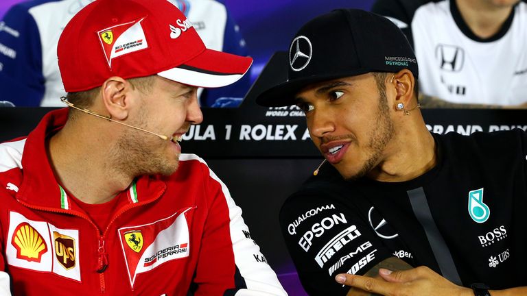 Lewis Hamilton of Great Britain and Mercedes GP speaks with Sebastian Vettel of Germany and Ferrari during the drivers' p