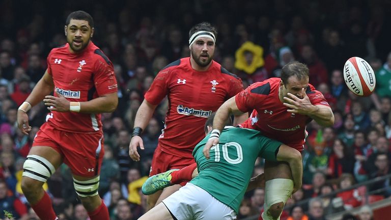 Wales's centre Jamie Roberts (R) loses the ball as he's tackled by Ireland's fly half Johnny Sexton