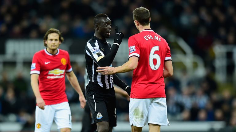 Manchester United player Jonny Evans (r) looks on as Papiss Cisse of Newcastle has words 