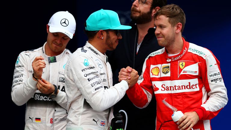 Lewis Hamilton celebrates with Sebastian Vettel as Nico Rosberg watches on